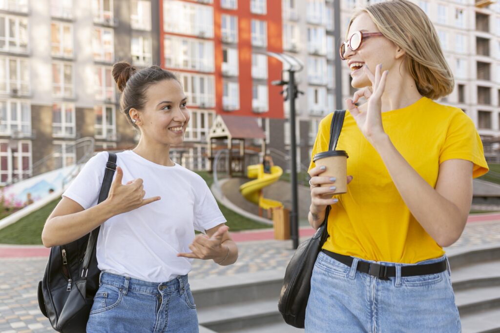 female friends outside using sign language